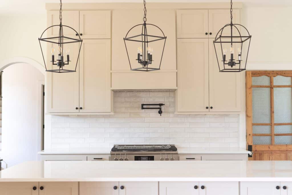 accessible beige kitchen cabinets with black hardware and black latern pendants in Walker County, TX
